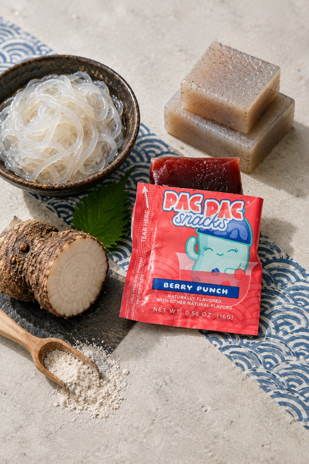Shirataki noodles, konnyaku blocks, raw konjac root, and a Pac Pac Berry Punch konjac chew arranged together